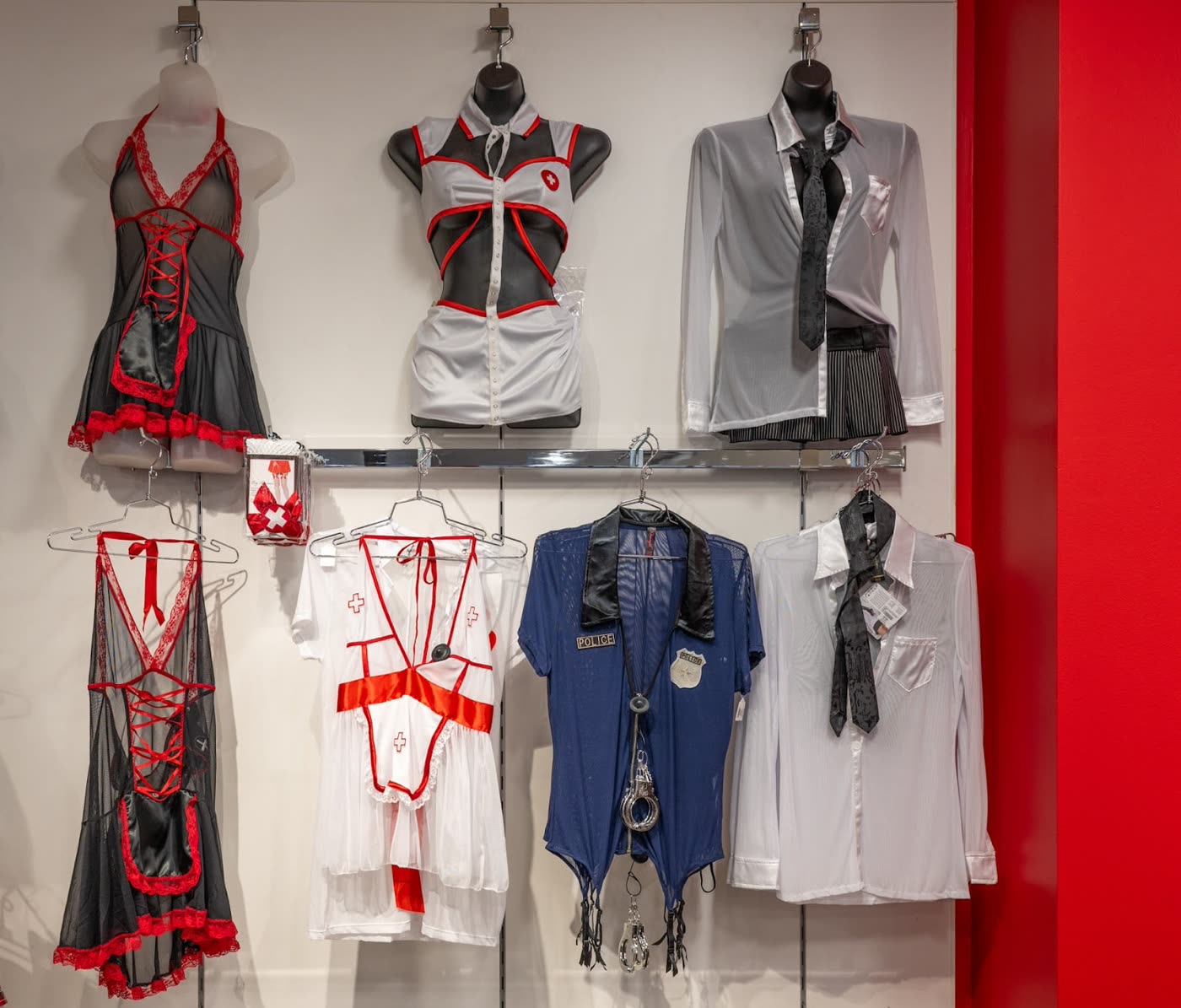 The costume wall at the Spice boutique in Santa Rosa: Halloween costumes on mannequin forms and hangers against a white wall with a red column